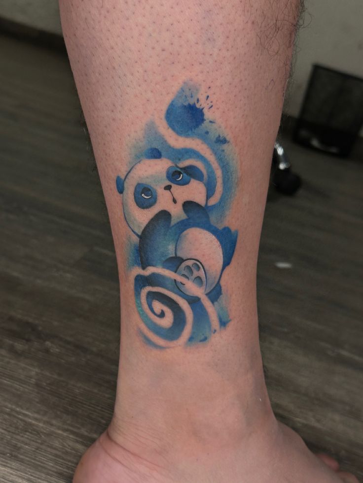 a tattoo on the leg of a person with a blue and white panda bear design