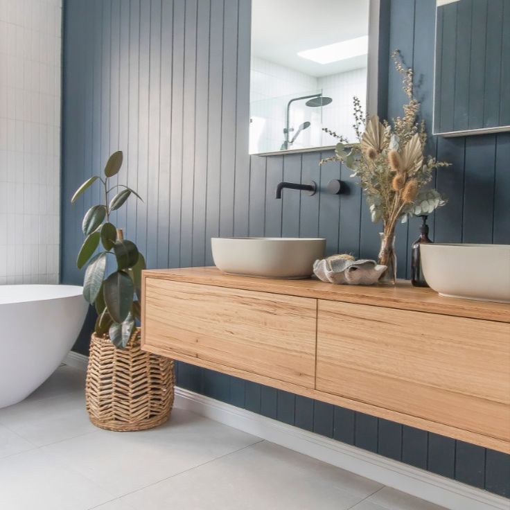 a bathroom with two sinks and a bathtub next to each other in front of a mirror