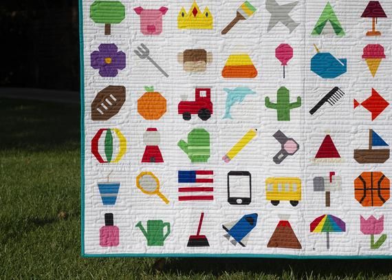 a quilted wall hanging on the side of a grass covered field