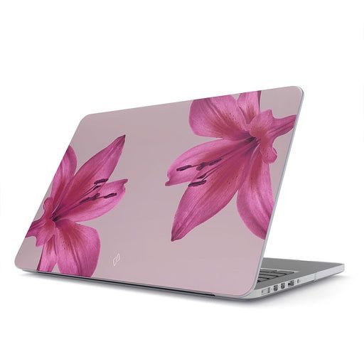 an open laptop computer sitting on top of a white surface with pink flowers painted on it