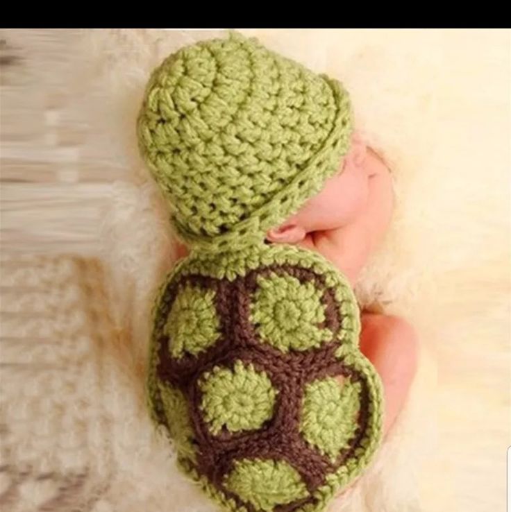 a newborn baby wearing a crocheted turtle hat