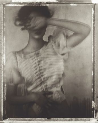 an old black and white photo of a woman with her hair blowing in the wind