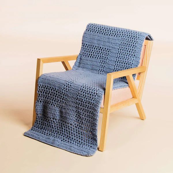 a wooden chair with a blue crocheted blanket on it