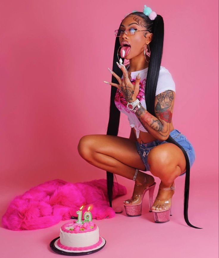 a woman kneeling down with a cake in front of her