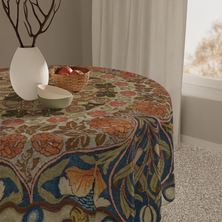 a table topped with a bowl of fruit next to a vase