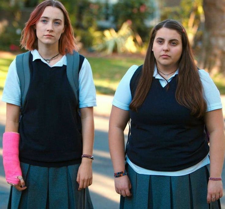 two girls with cast on their arms standing next to each other