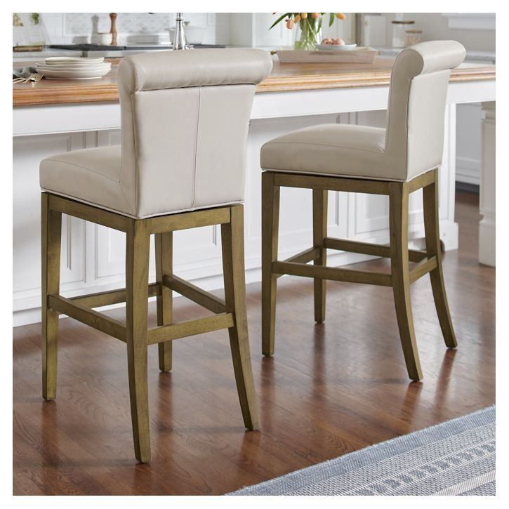 two white and gold barstools in front of a kitchen counter with wooden floors