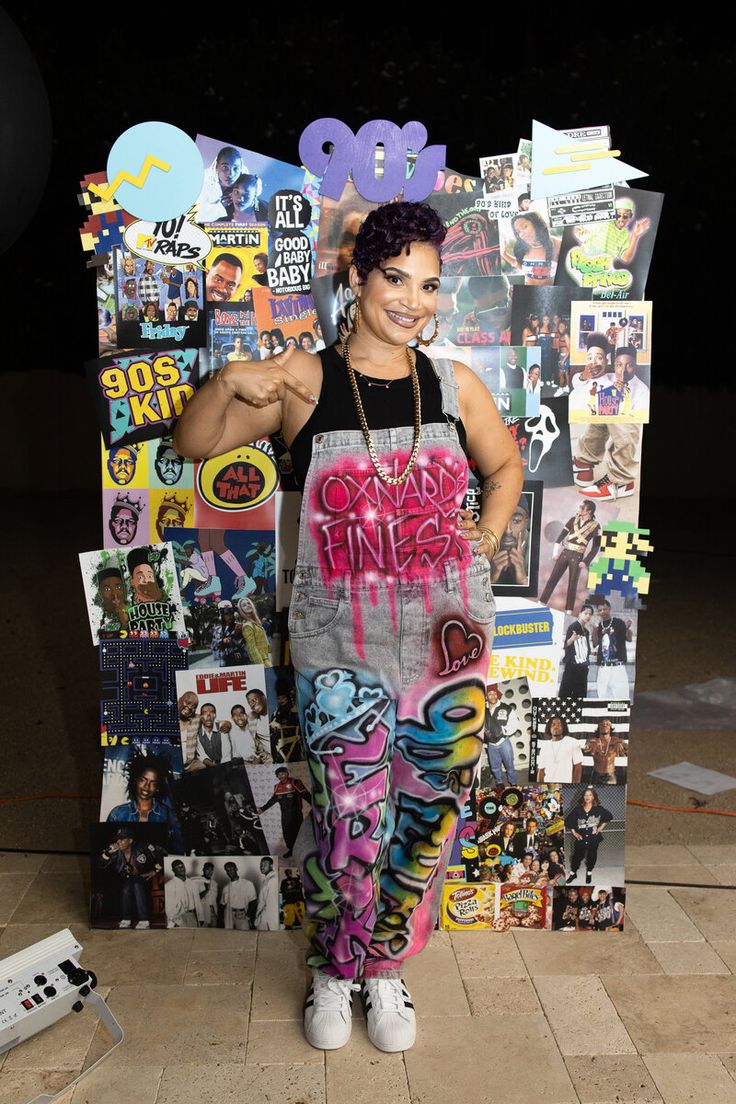 a woman standing in front of a wall covered with stickers