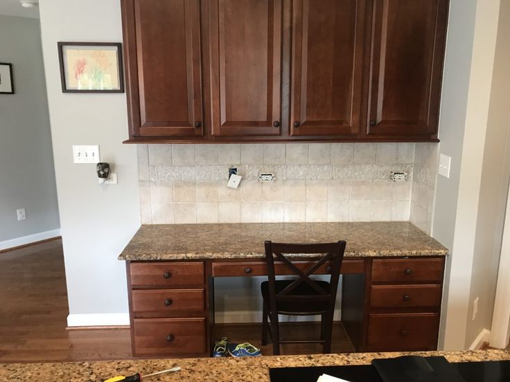 a kitchen with wooden cabinets and marble counter tops