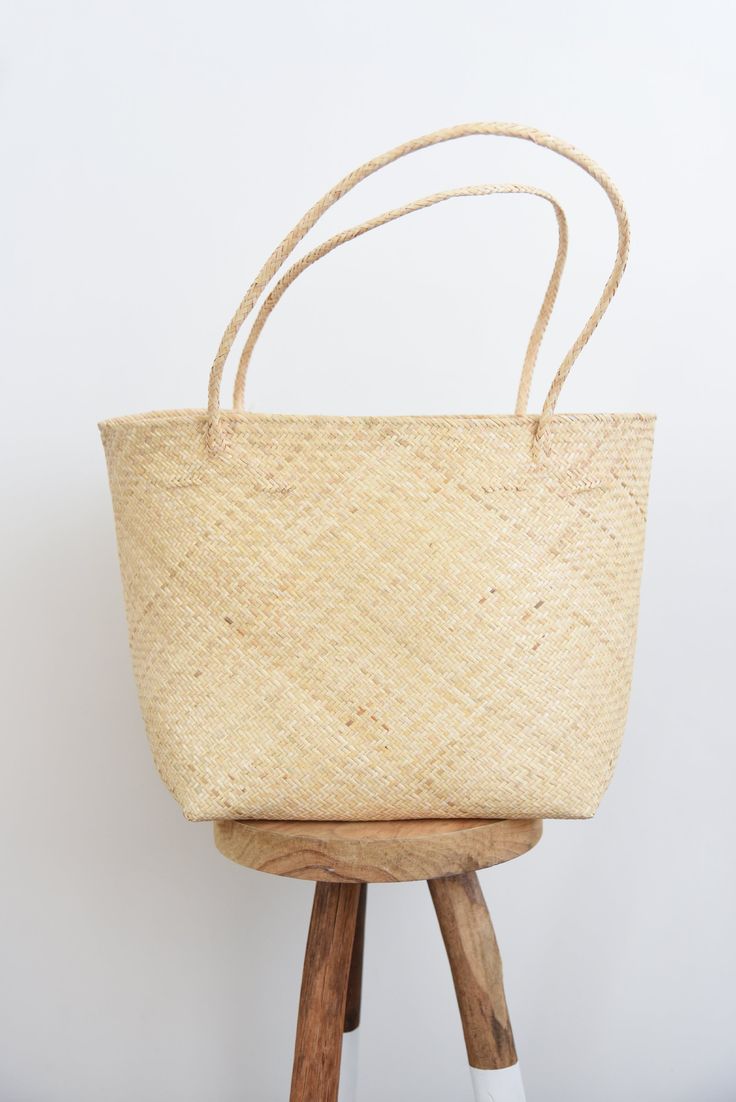 Style // A natural and hand woven basket Our Bali Bag is a classic Day Tote, designed to allow you to bring anything you need along, without packing 12 bags. Fit it all in style and no longer go without! The perfect bag for shopping, beach days, coffee shop lockdowns, or literally anytime you are gone all day. Fabric Note // Hand woven in Bali, Indonesia from 100% Borneo Rattan Sizing Advice // Available in one size Body: 19"L x 12"H x 8"W Straps: 9.5" Care Instructions // Treat it with love and Eco-friendly Rattan Beach Bag For Spring, Eco-friendly Rattan Basket Beach Bag, Eco-friendly Handwoven Basket Beach Bag, Eco-friendly Rattan Shoulder Bag For Beach, Eco-friendly Handwoven Rattan Beach Bag, Easter Essentials, Ring Sling, Clothes Basket, Hand Woven Baskets