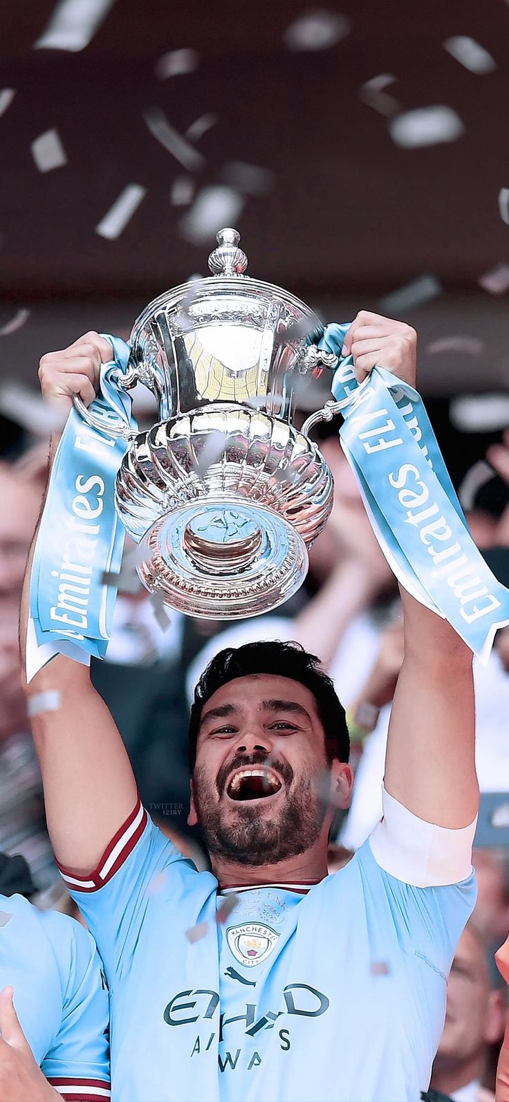 a man holding up a trophy in front of a crowd