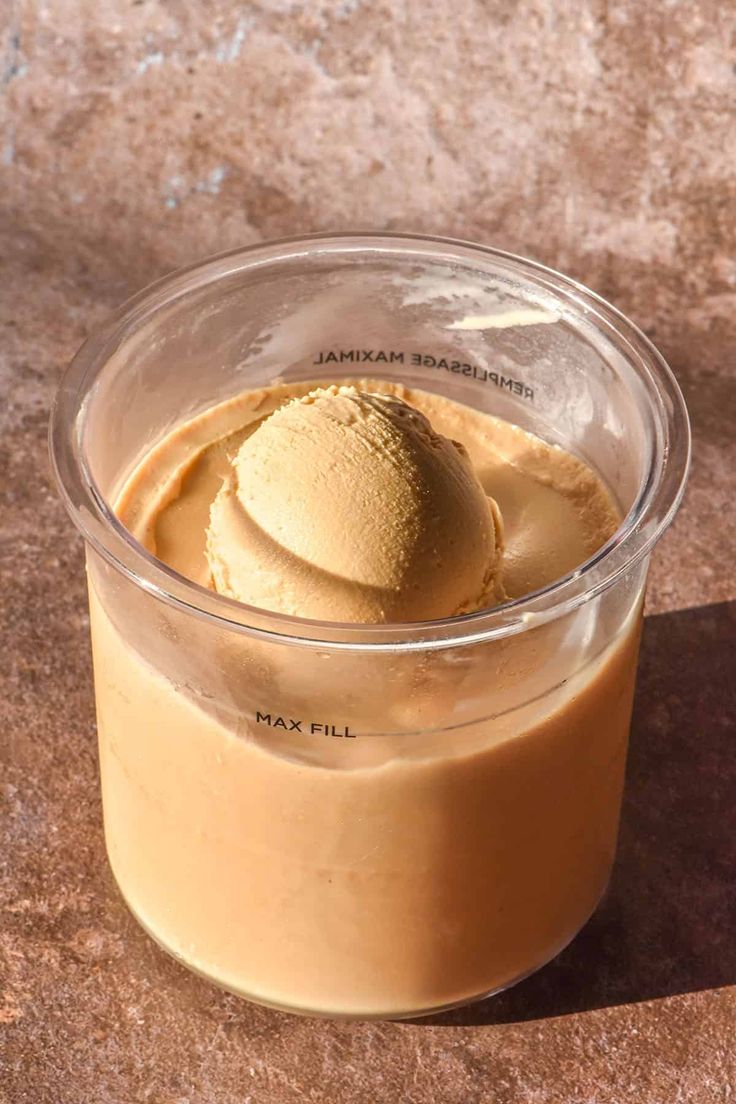 an ice cream dessert in a plastic container on a table with a brown marble surface