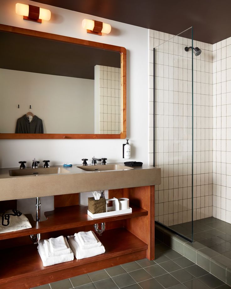 a bathroom with a sink, mirror and shower stall in the middle of the room