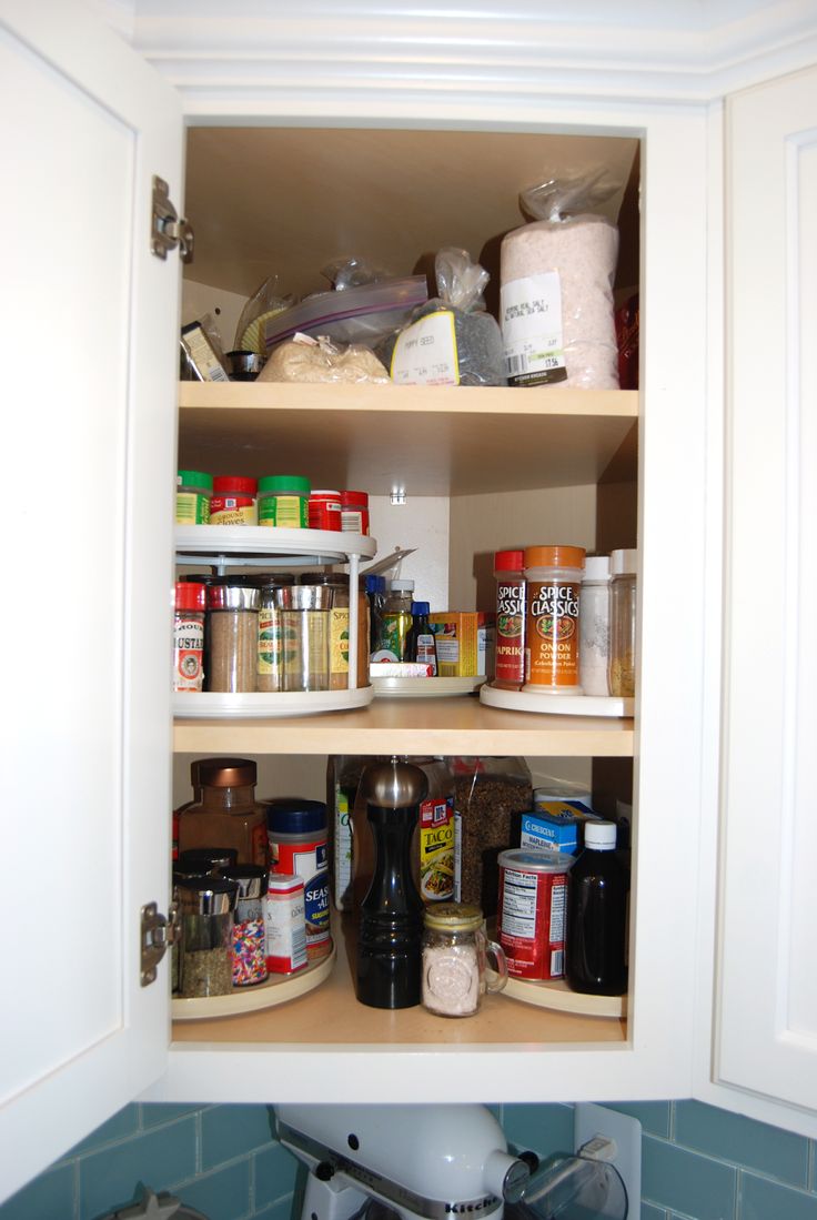 an open cabinet in a kitchen filled with food