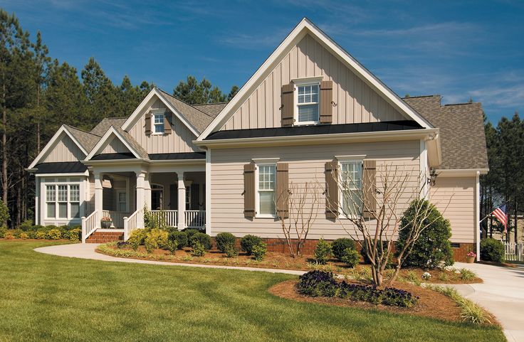 a house with landscaping in front of it and lots of grass around the yard area