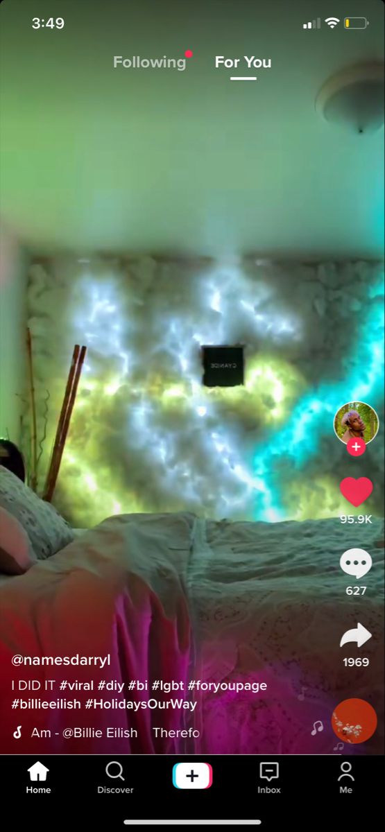 a bed room with a neatly made bed and colorful lights on the wall