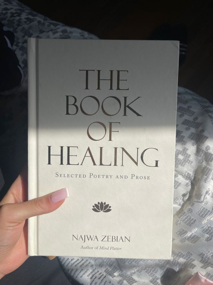 the book of healing is being held up in front of someone's hand