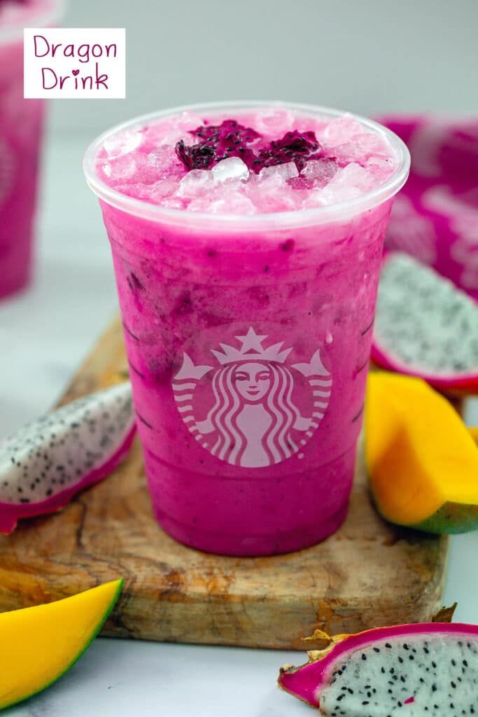 a pink drink sitting on top of a wooden cutting board