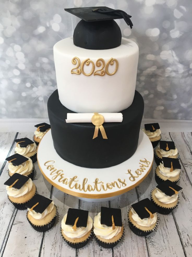 a graduation cake and cupcakes on a table