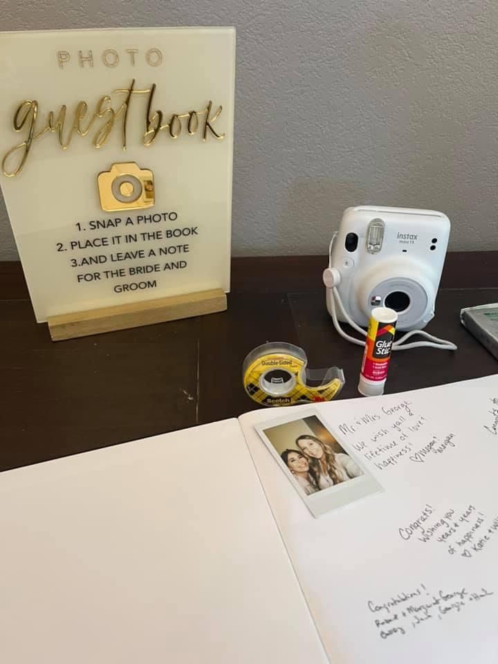 an open photo book sitting on top of a table next to a camera and other items