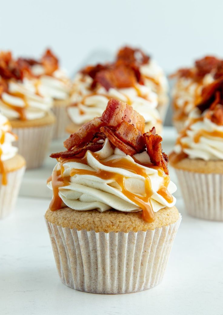 several cupcakes with bacon and white frosting