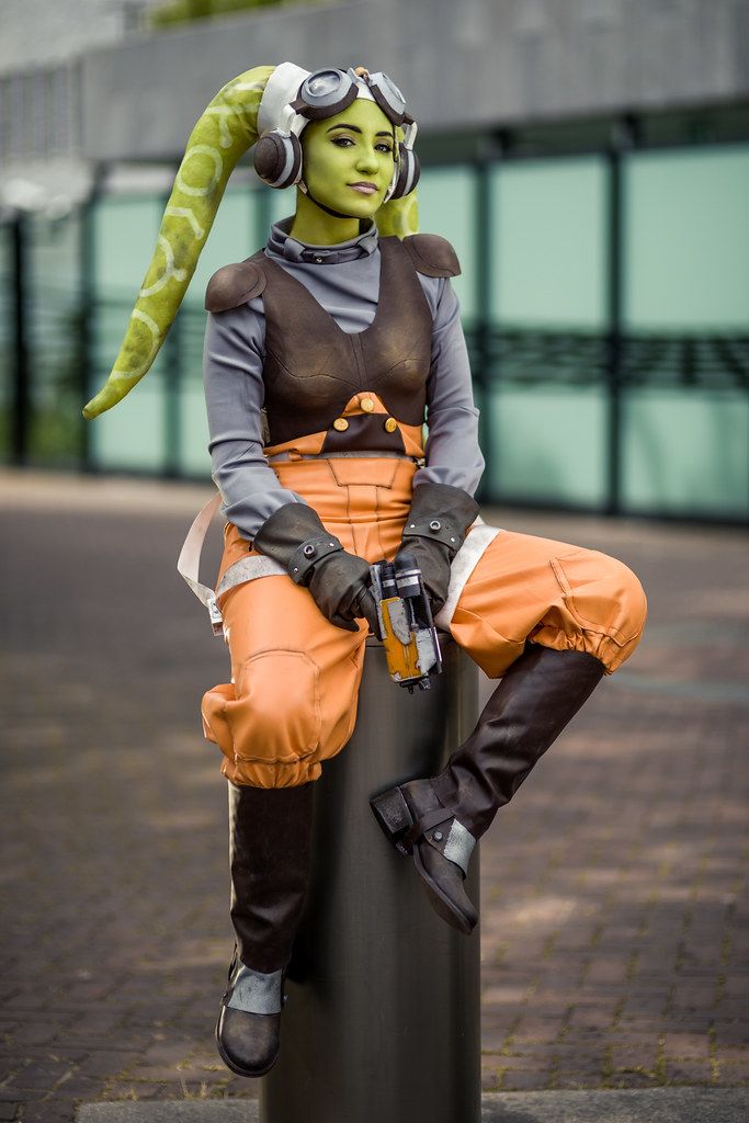 a person in costume sitting on top of a pole