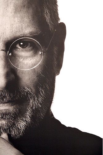 a man with glasses and a beard is posing for a photo in front of a white background