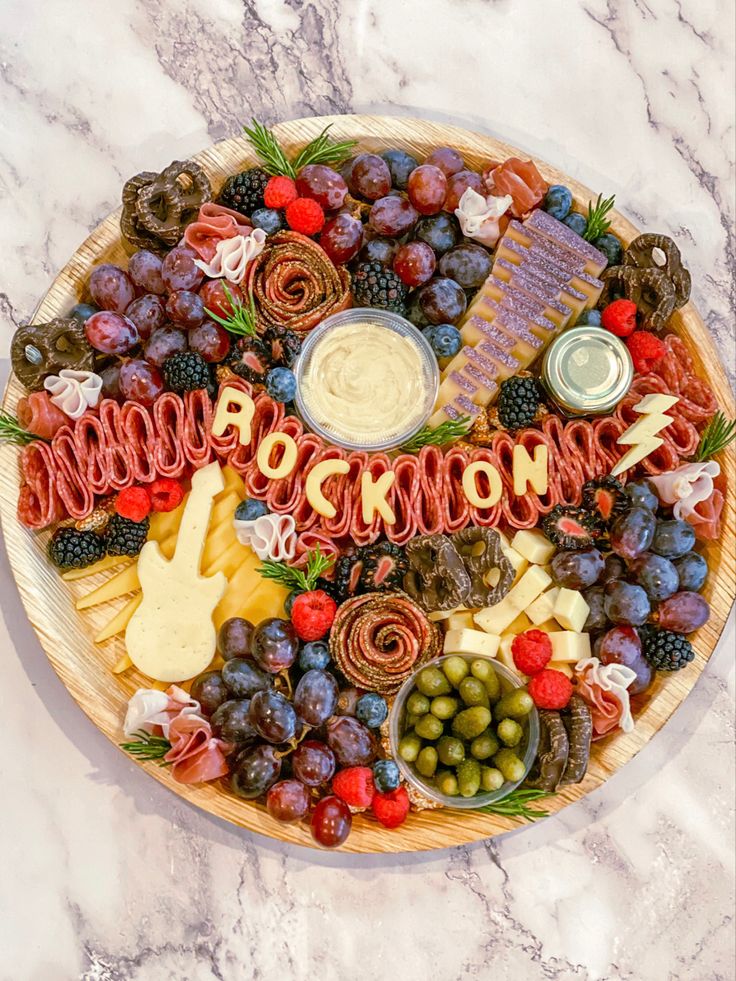 a platter filled with lots of different types of food on top of a marble counter