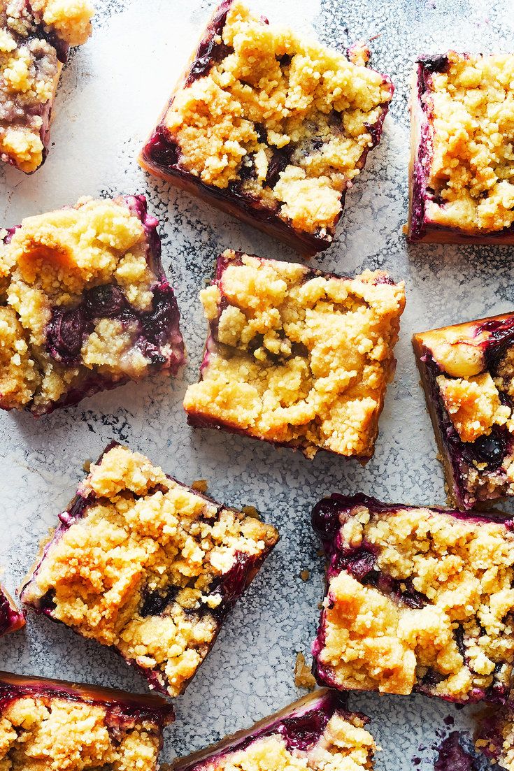 blueberry crumb bars are arranged on a baking sheet, ready to be eaten