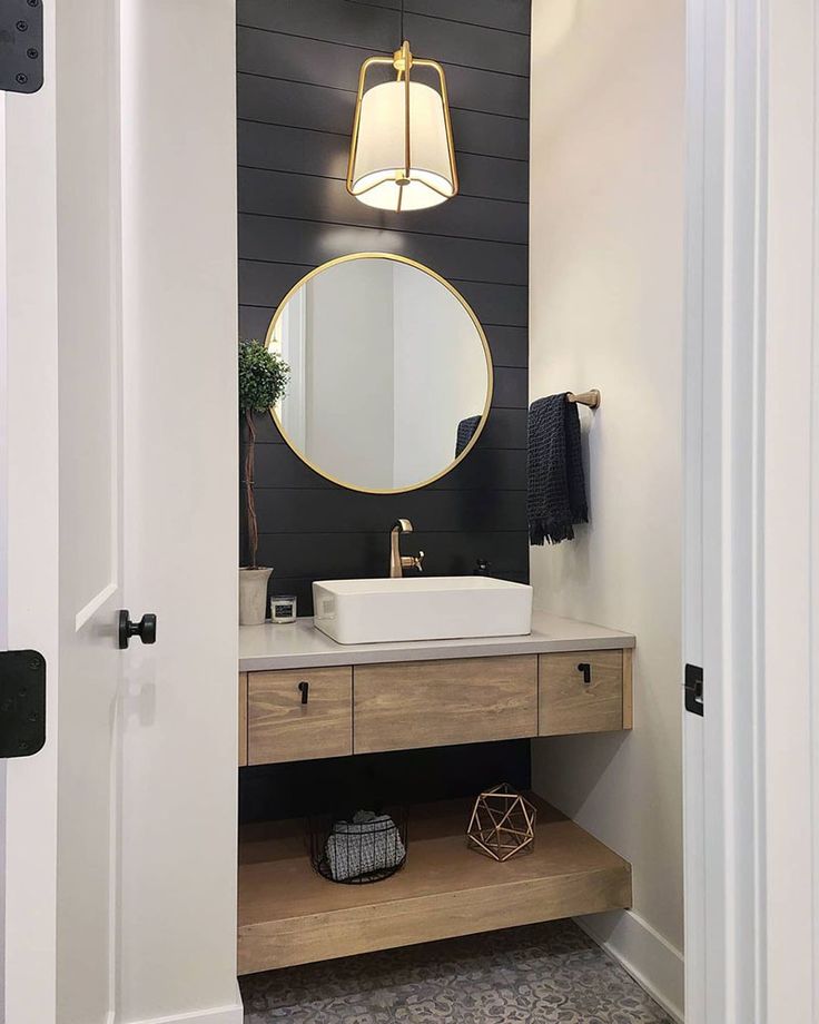 a bathroom with a sink, mirror and lights on the wall next to an open door