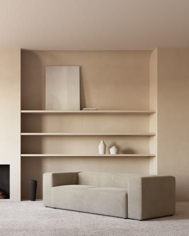 a white couch sitting in front of a fire place next to a book shelf filled with books