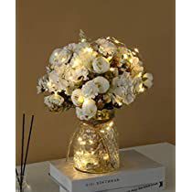 a vase filled with white flowers sitting on top of a table