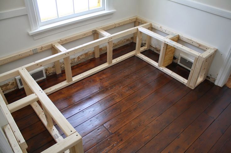 an empty room with wood flooring and windows