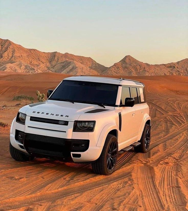 a white suv is driving through the desert