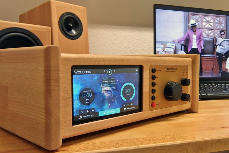 a radio sitting on top of a wooden table next to a computer monitor and keyboard