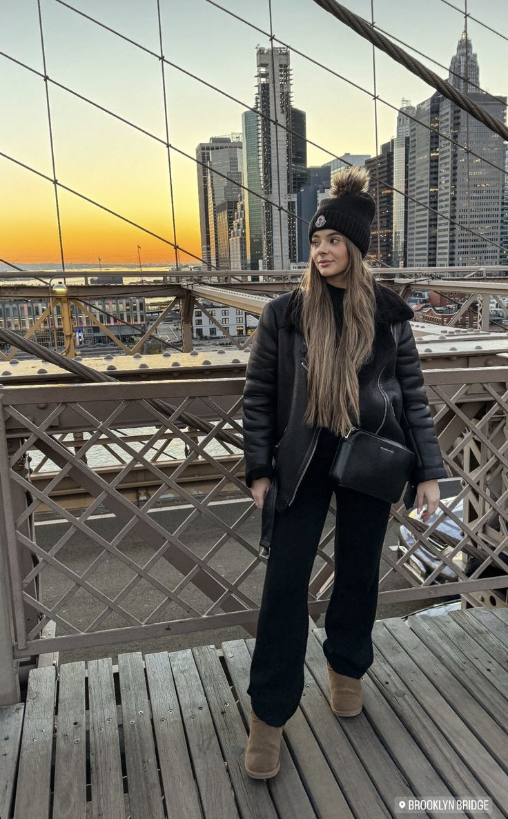 a woman standing on top of a bridge next to a tall cityscape with buildings in the background