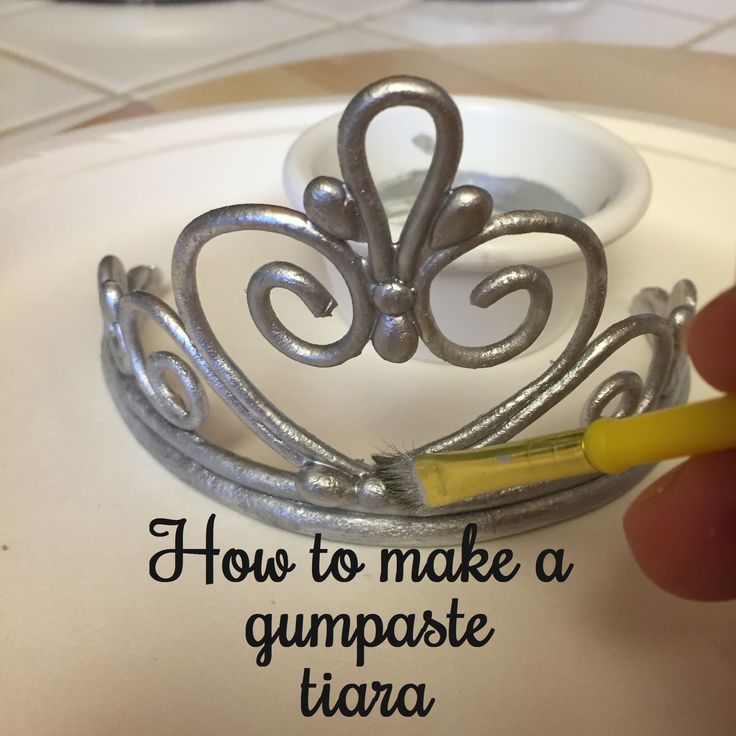 someone is making a tiara out of metal wire and glues it with a yellow marker