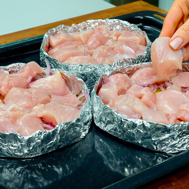 three tin foil pans filled with raw meat