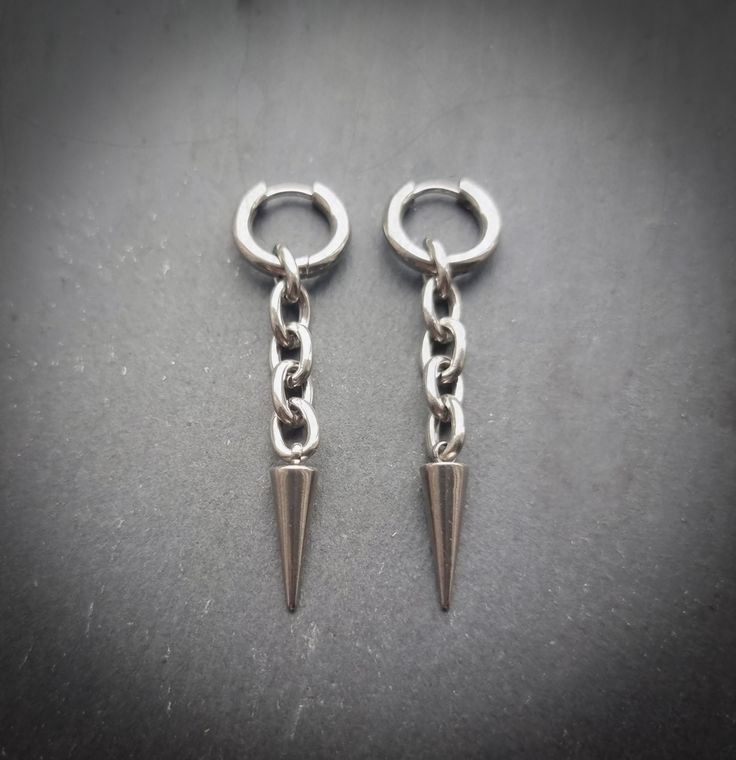 Stunning silver spike and chain link earrings! Unisex. Sold as a pair  Made of high quality stainless steel. Also available in gold! Spike measures 21mm hoops measure 15mm  Please don't hesitate to contact me with any queries or suggestions 😊  Comes gift wrapped 💜 Silver Stainless Steel Punk Hoop Earrings, Punk Style Silver Stainless Steel Hoop Earrings, Silver Dangle Punk Piercings, Edgy Silver Jewelry In Surgical Steel, Edgy Silver Jewelry Made Of Surgical Steel, Edgy Silver Surgical Steel Jewelry, Edgy Silver Metal Piercings, Nickel Free Metal Edgy Piercings, Nickel-free Edgy Metal Piercings