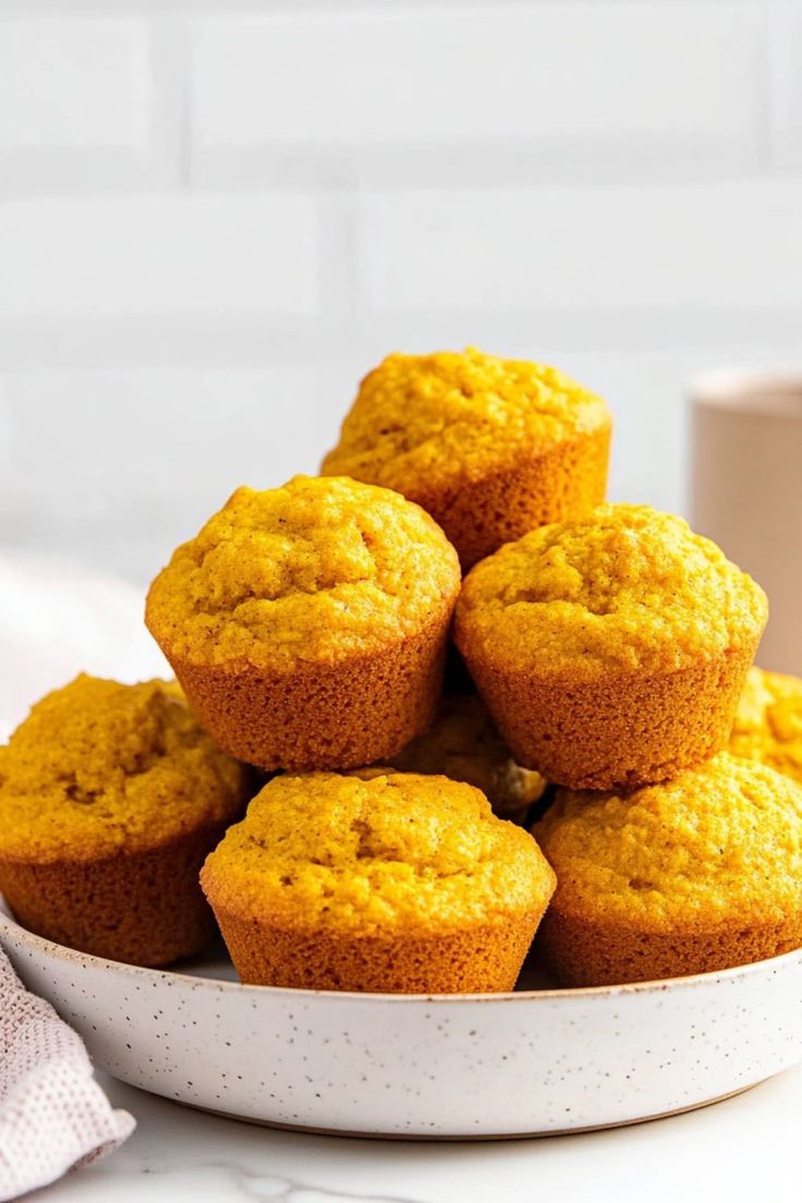 a white bowl filled with muffins on top of a table