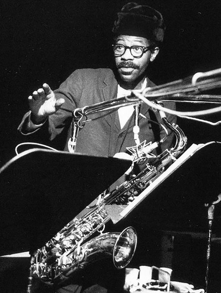 a black and white photo of a man playing the saxophone