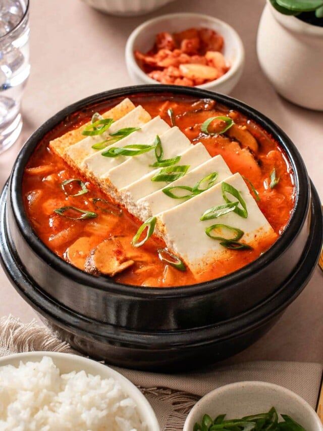 there are many different dishes on the table with rice and sauces in bowls next to each other