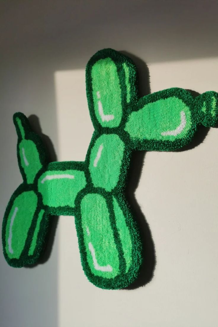 a close up of a stuffed animal on a white surface with green paint and black trim