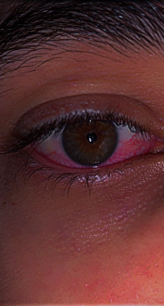 a close up of a person's eye with red and blue eyeshadow