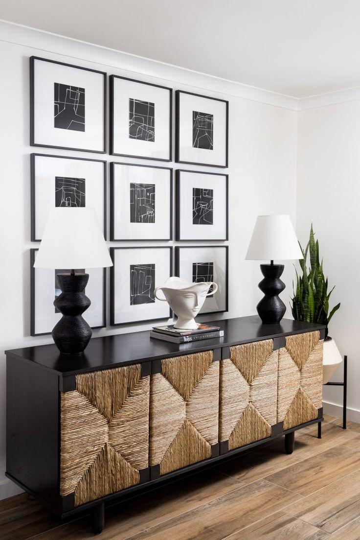 a living room with pictures on the wall and a sideboard in front of it