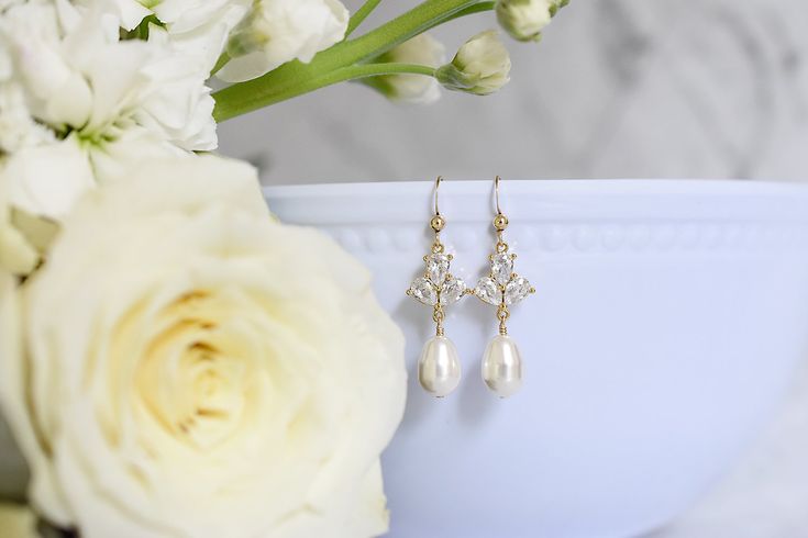 Dainty yet glamorous, The Rose Earrings in Gold, are the perfect accessory to accent a bateau neckline for both you and your bridesmaids. The subtle sparkle adds a touch of elegance to your wedding day look. Size: 1.5" long Materials: cubic zirconia, Swarovski pearls in white Metals: gold filled ear wires and components Find the matching necklace here Elegant Crystal Bridal Accessories For Anniversary, Elegant Gold Earrings For Bridesmaids, Gold Elegant Crystal Earrings For Bridesmaid, Classic Rose Gold Bridal Earrings For Wedding, Elegant Crystal Earrings For Wedding, Elegant Bridal Accessories For Anniversary, Elegant White Bridal Accessories For Bridesmaid, Elegant White Crystal Earrings For Bridesmaids, Elegant Pearl Drop Bridal Earrings For Bridesmaids