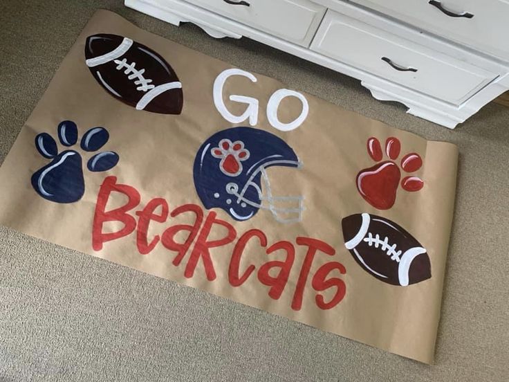 a door mat with footballs, paw prints and the word go bears on it