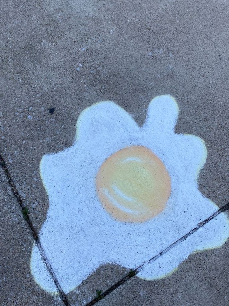 an egg is drawn on the sidewalk with chalk