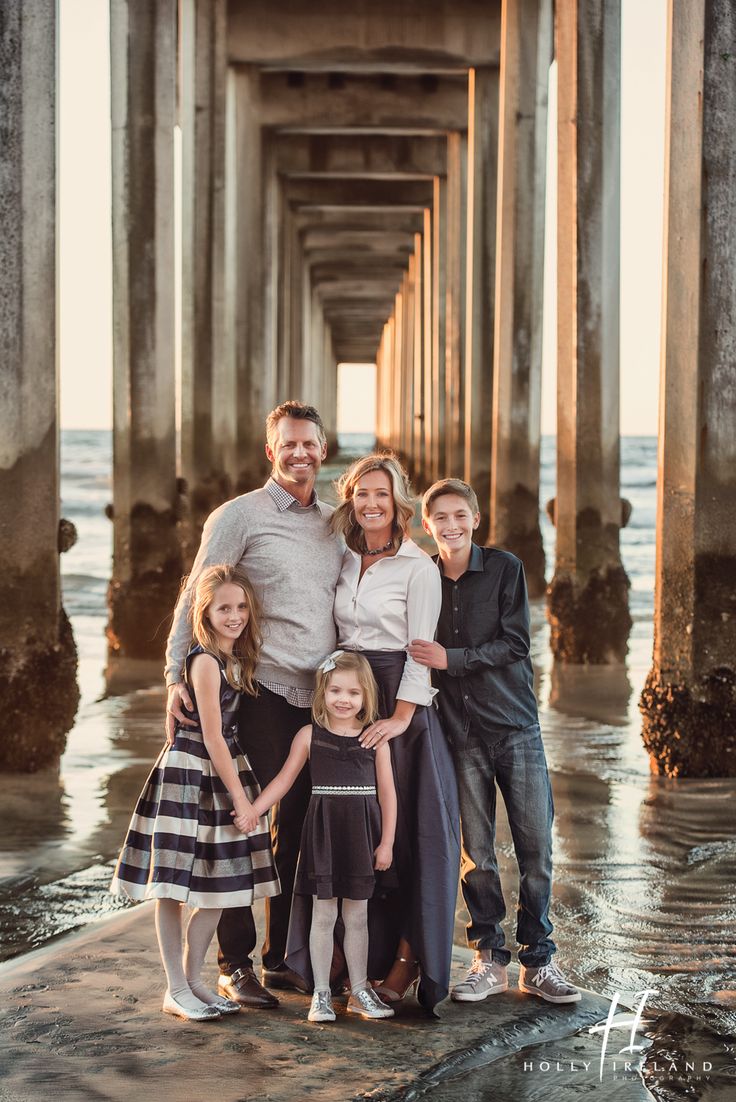 a family posing for a photo under the pier