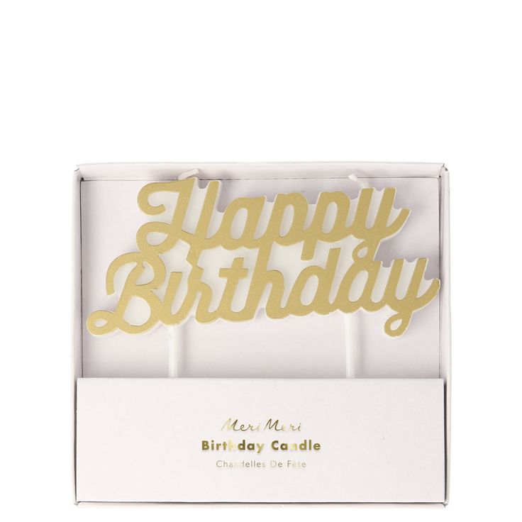 happy birthday cake topper in a white box with gold foil lettering on the front